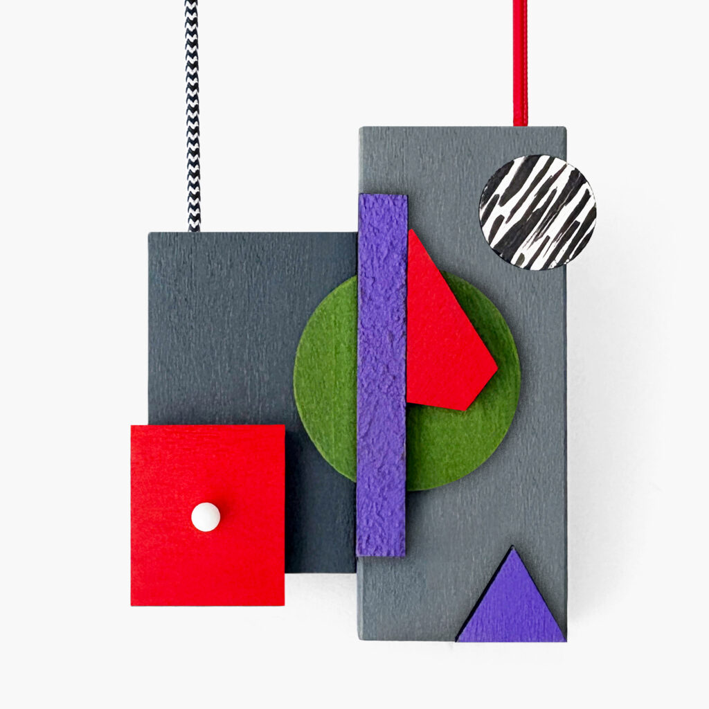 Red, purple and green geometric wooden necklace shown vertically on a white background