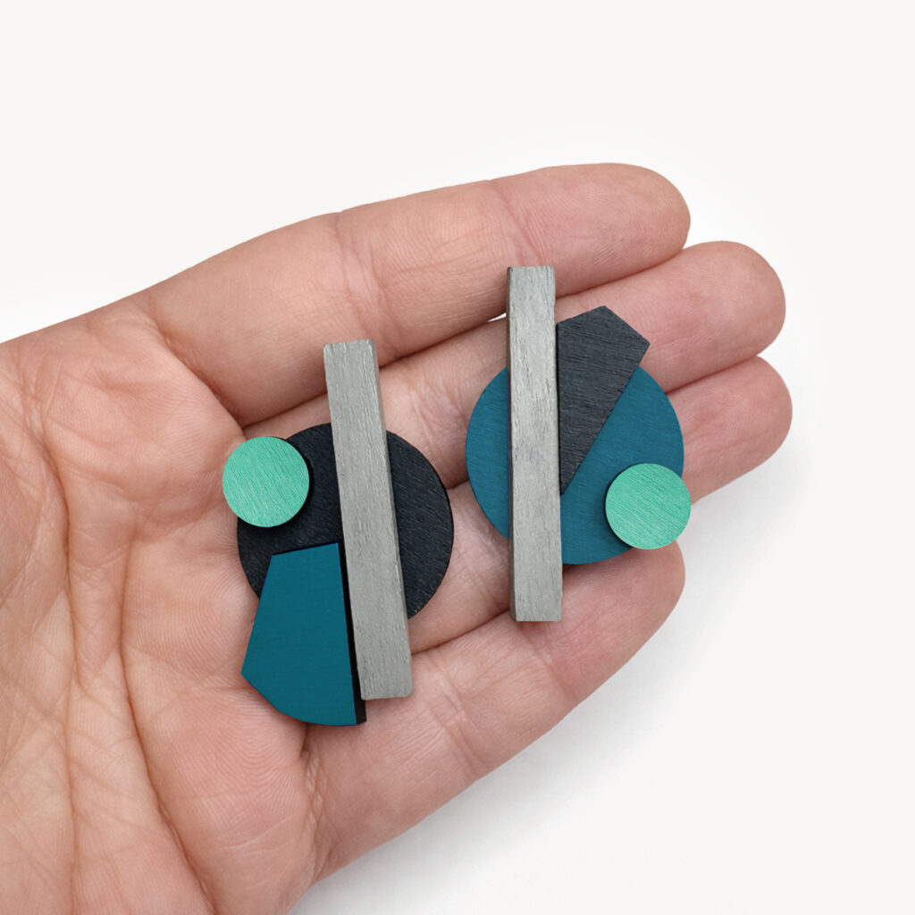 Turquoise and mint mismatched wooden earrings shown in hand
