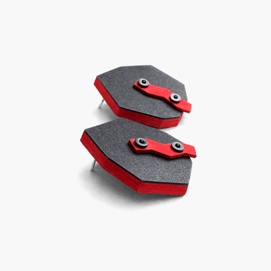 Side view of black red geometric wooden earrings showing the layered construction