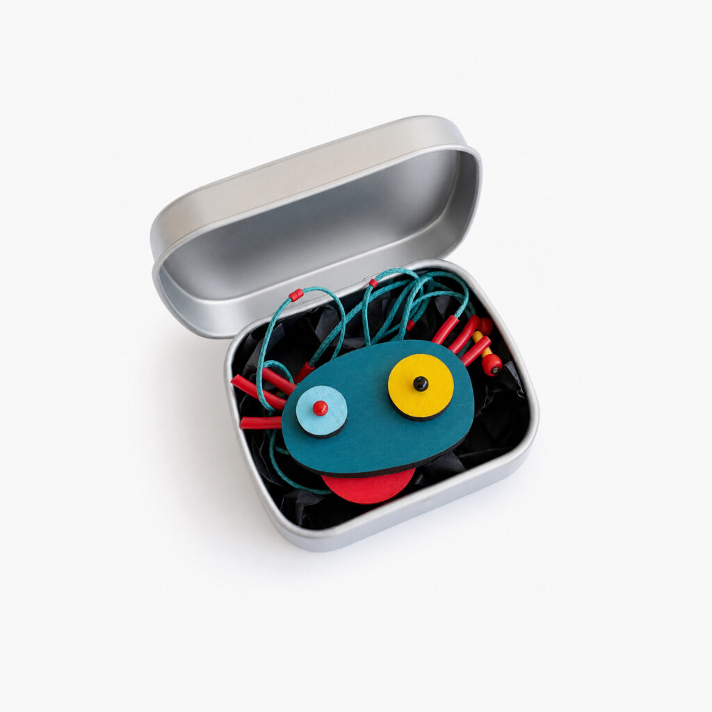 Colorful geometric axolotl necklace displayed in a metal gift box