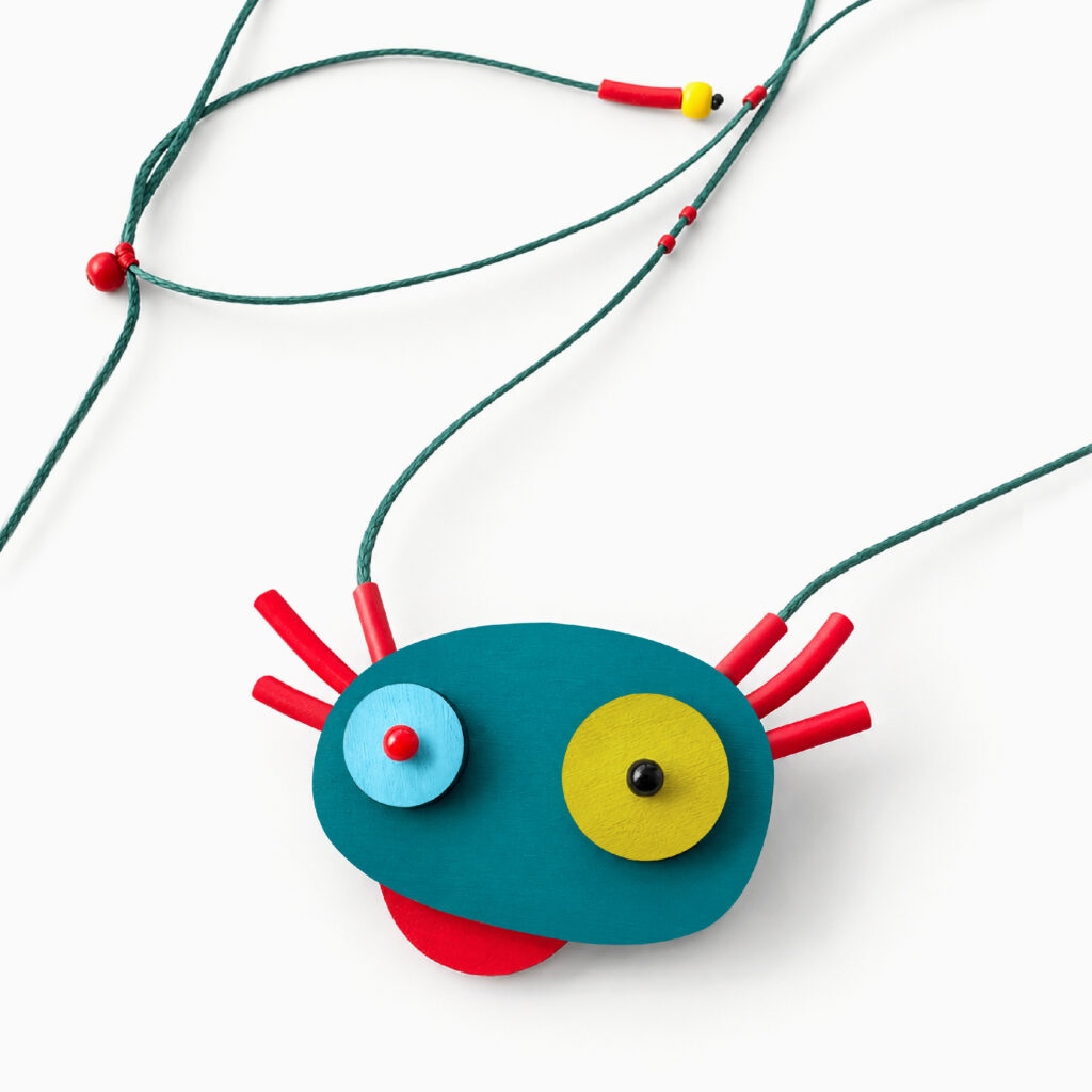 Close-up of playful axolotl pendant with red accents and adjustable turquoise cord