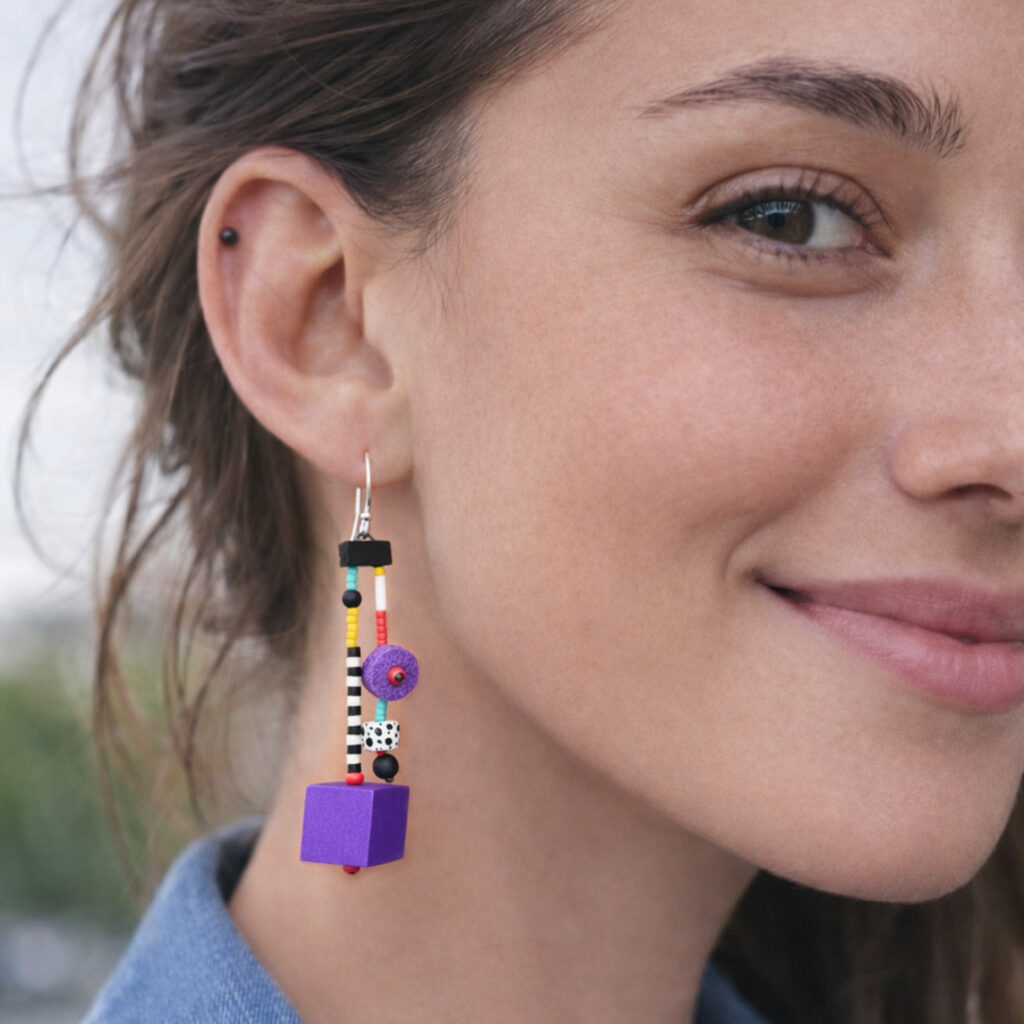 Long purple pop art earring with colorful beads and geometric shapes worn on ear