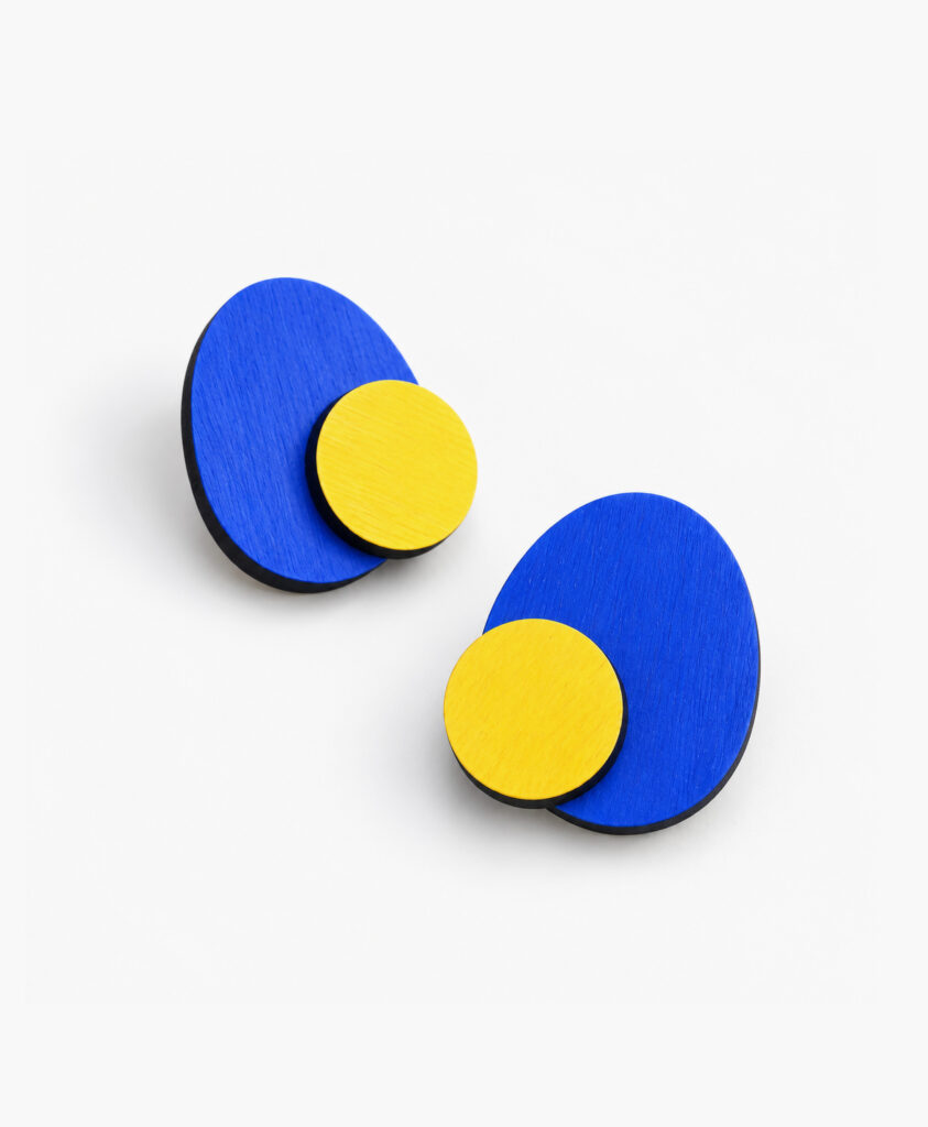 Blue geometric wooden stud earrings with contrasting yellow circles on a white background