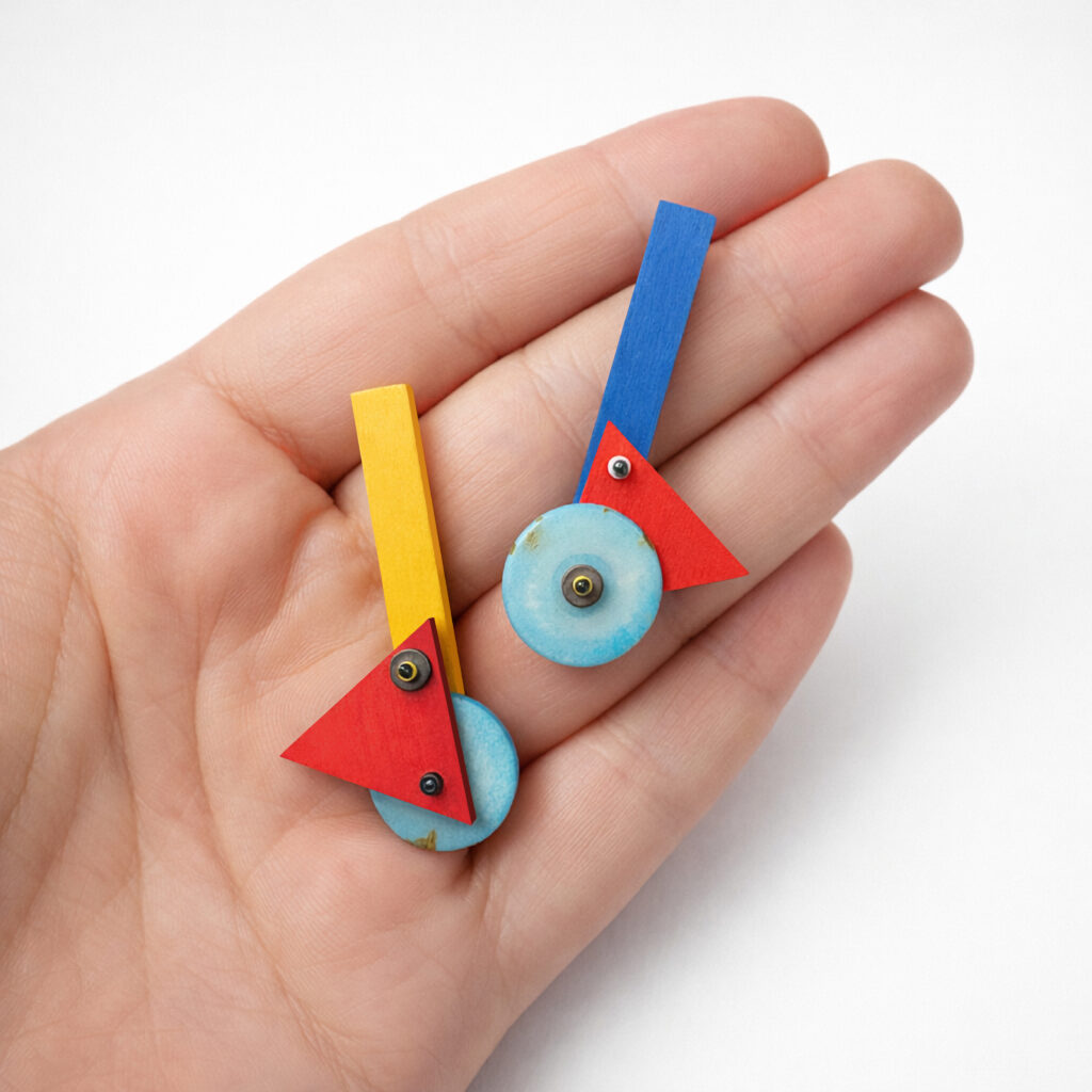 Colorful geometric statement earrings shown in hand
