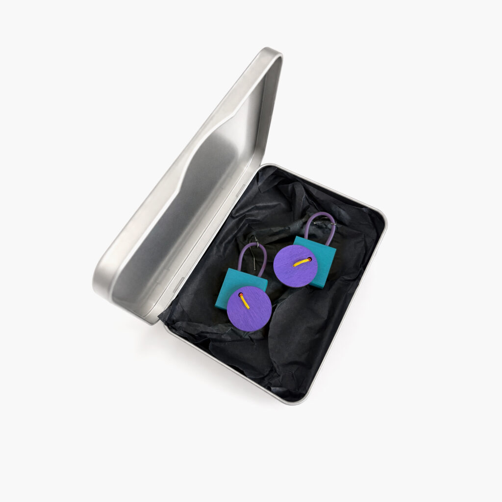 Purple and petrol handmade wooden earrings displayed in a metal gift box