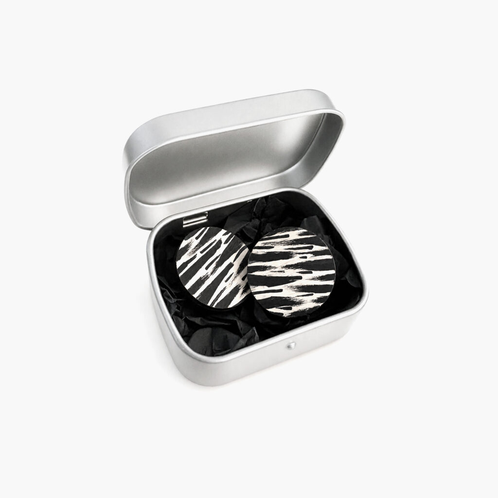 Black and white zebra print wooden stud earrings displayed in a metal gift box