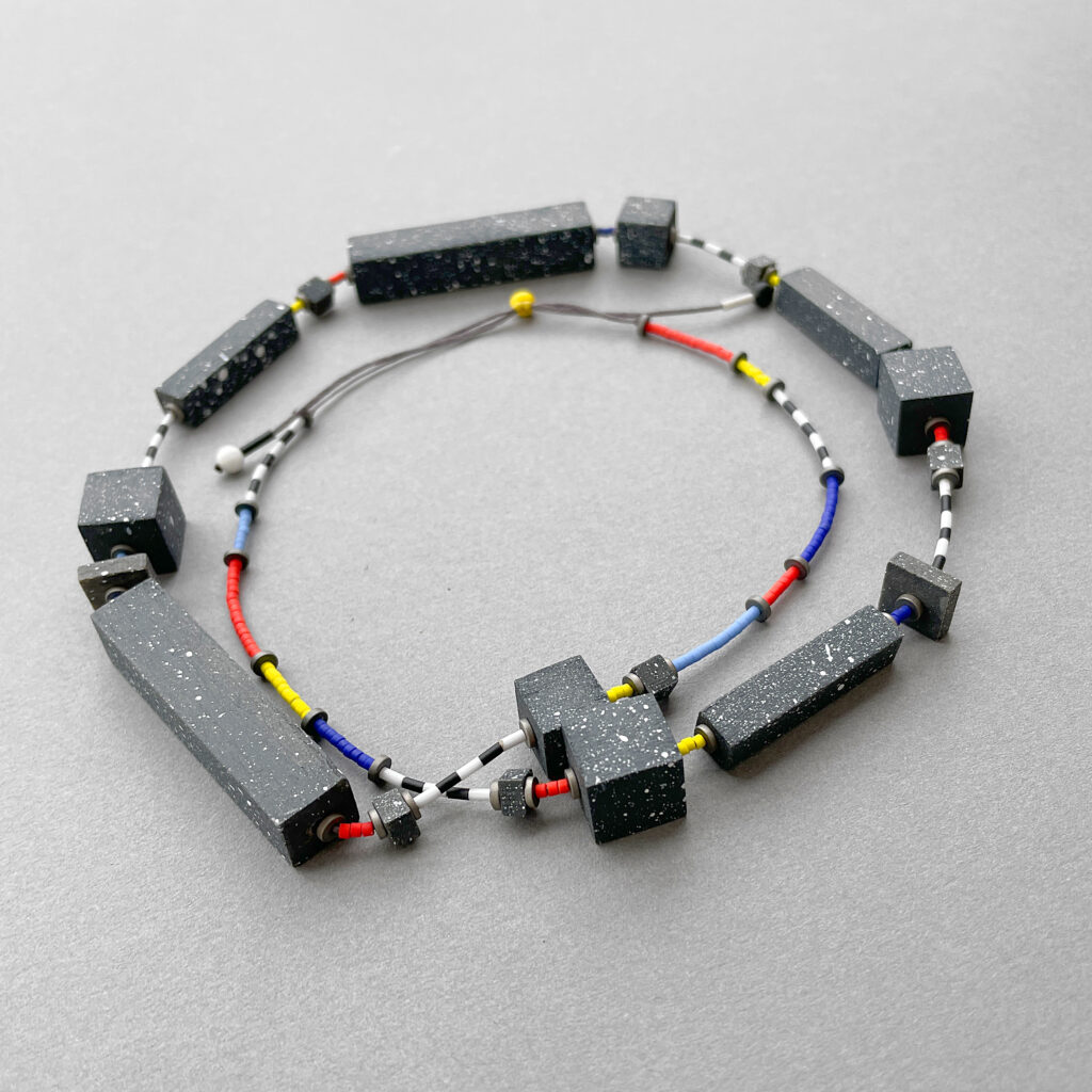 Speckled geometric statement necklace arranged in a circular composition showing its wooden elements
