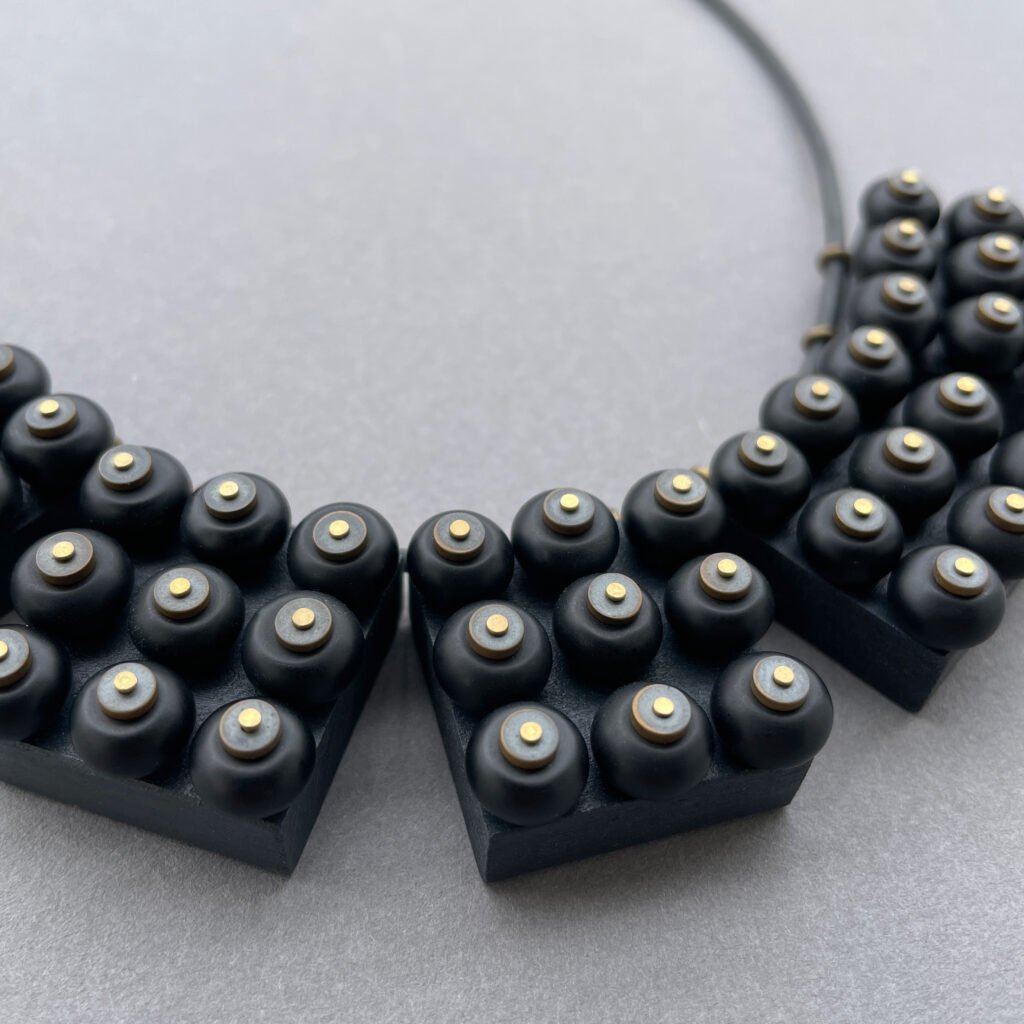 Close-up of black wooden geometric elements with round onyx beads