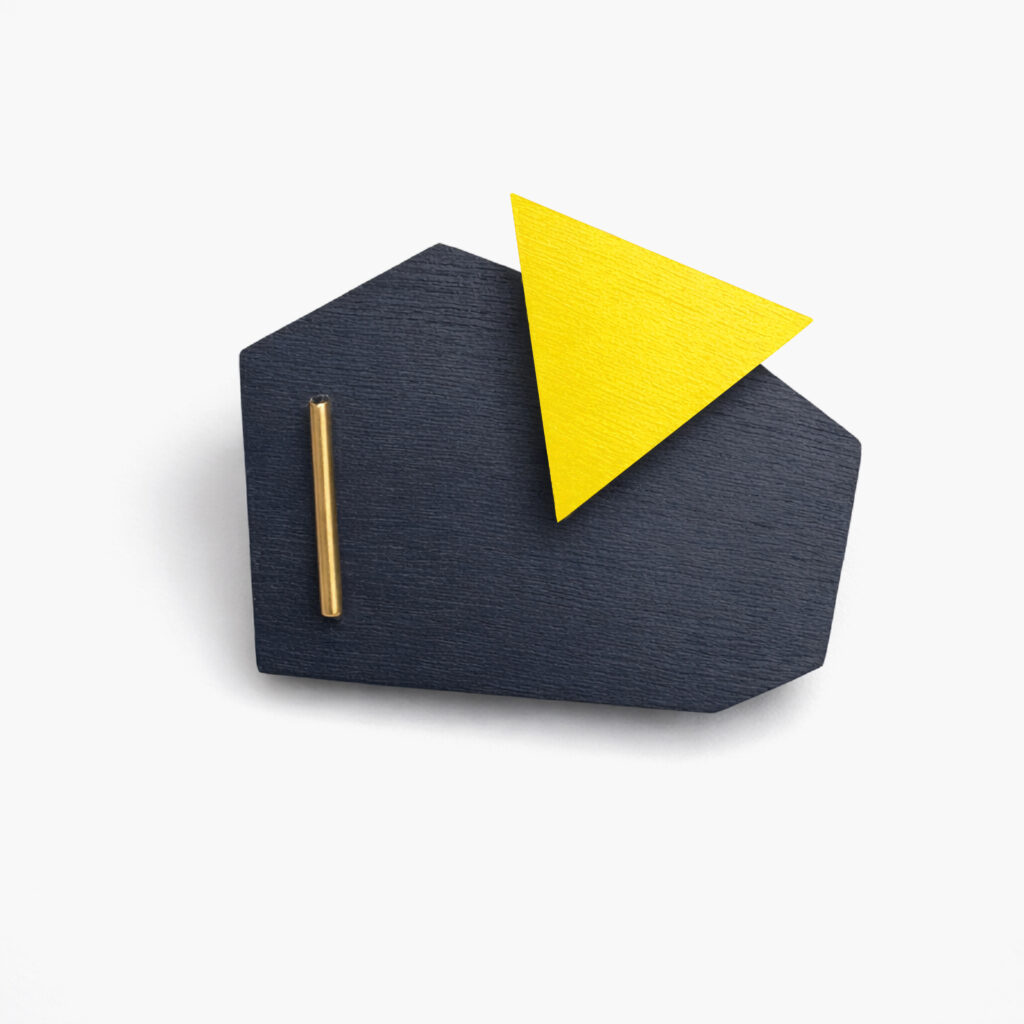 Black and yellow geometric wooden brooch with triangular detail on a white background